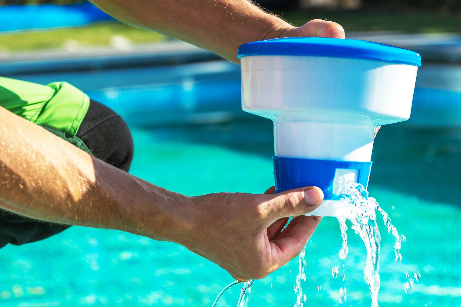 A man is pouring chemicals into a swimming pool.