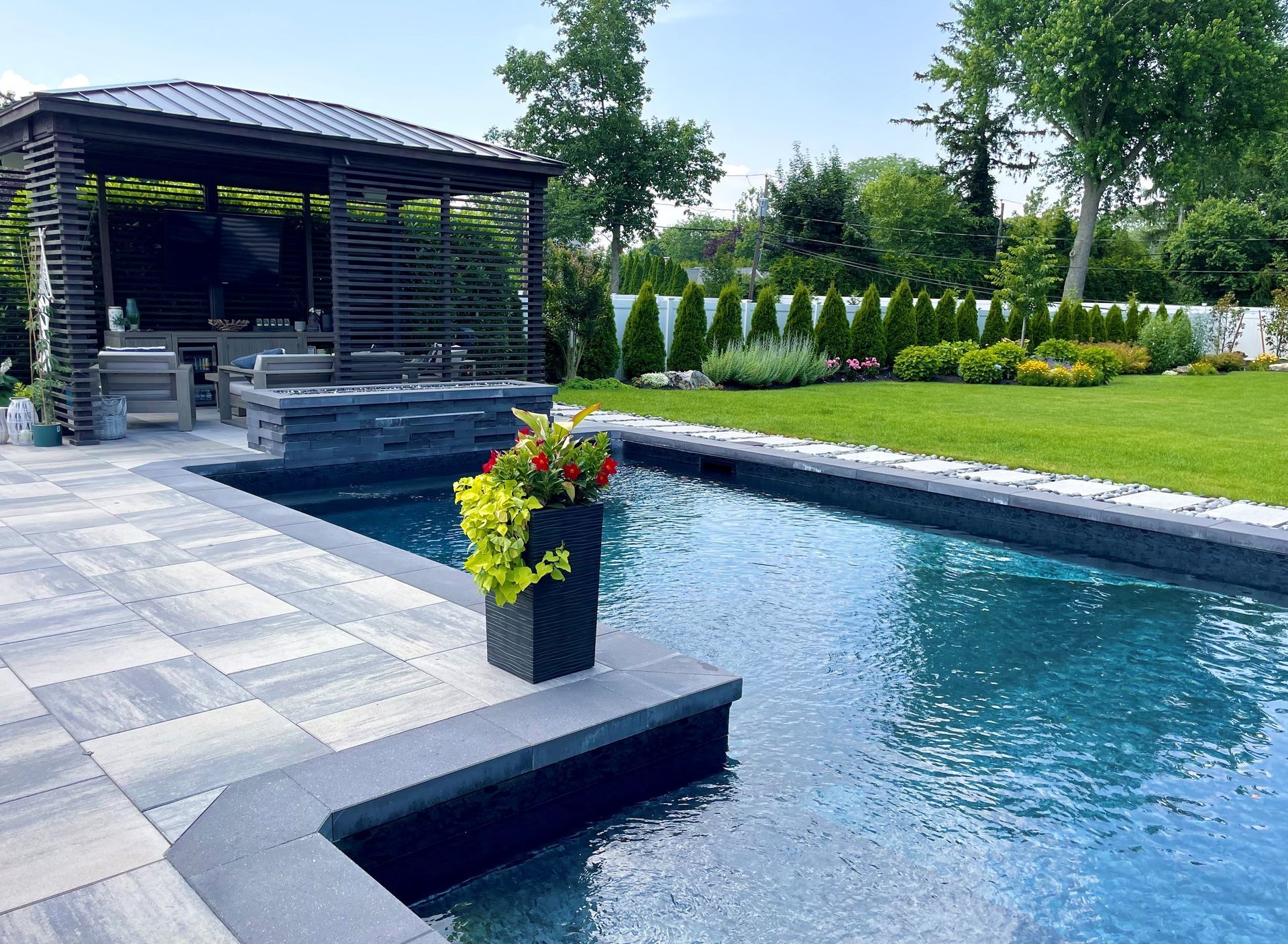 A large swimming pool in a backyard with a gazebo in the background.