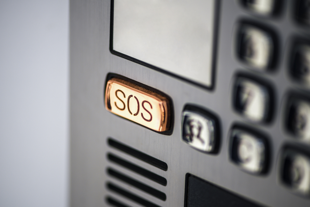 A close up of a sos button on a telephone.