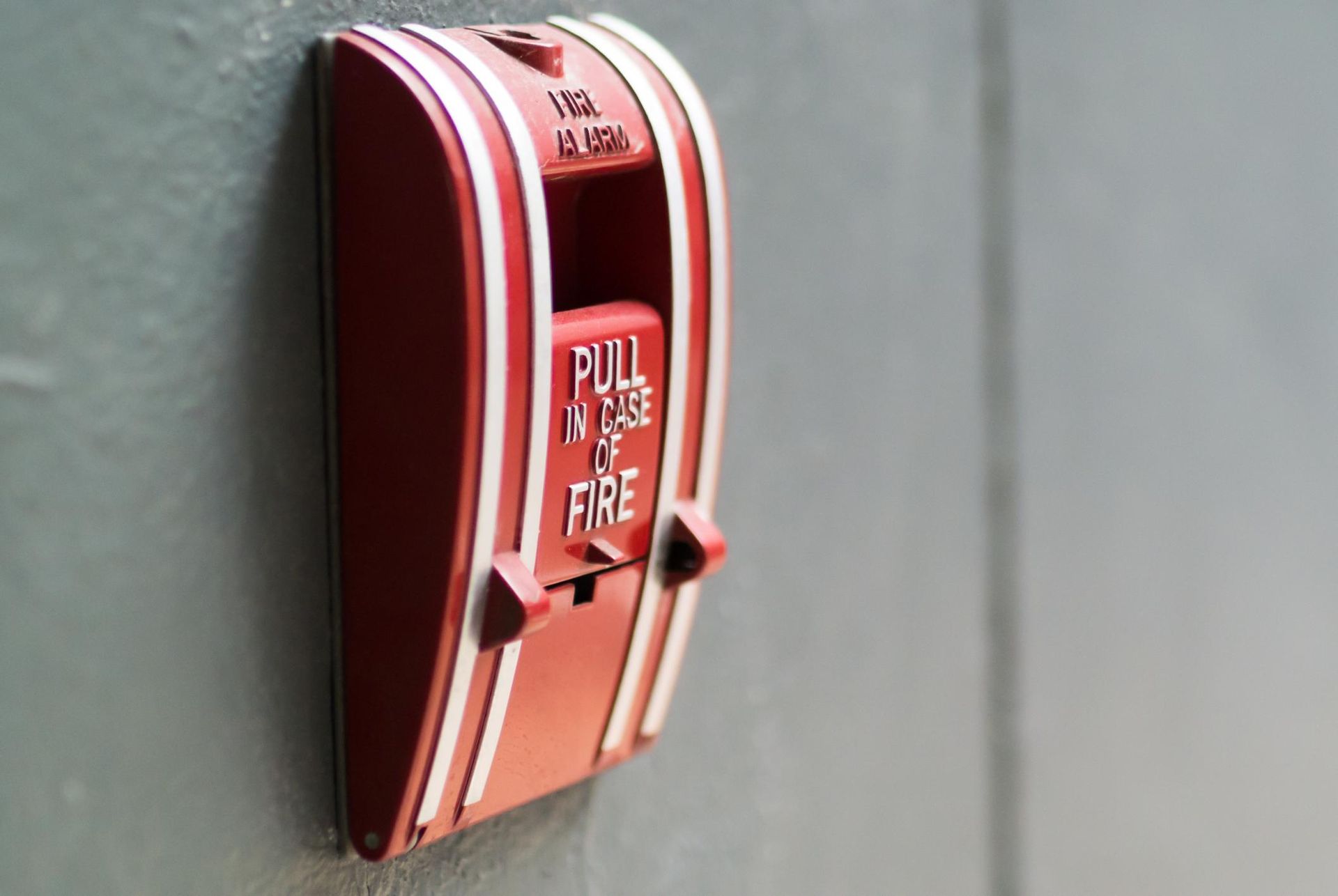 a red and white light switch on a gray wall