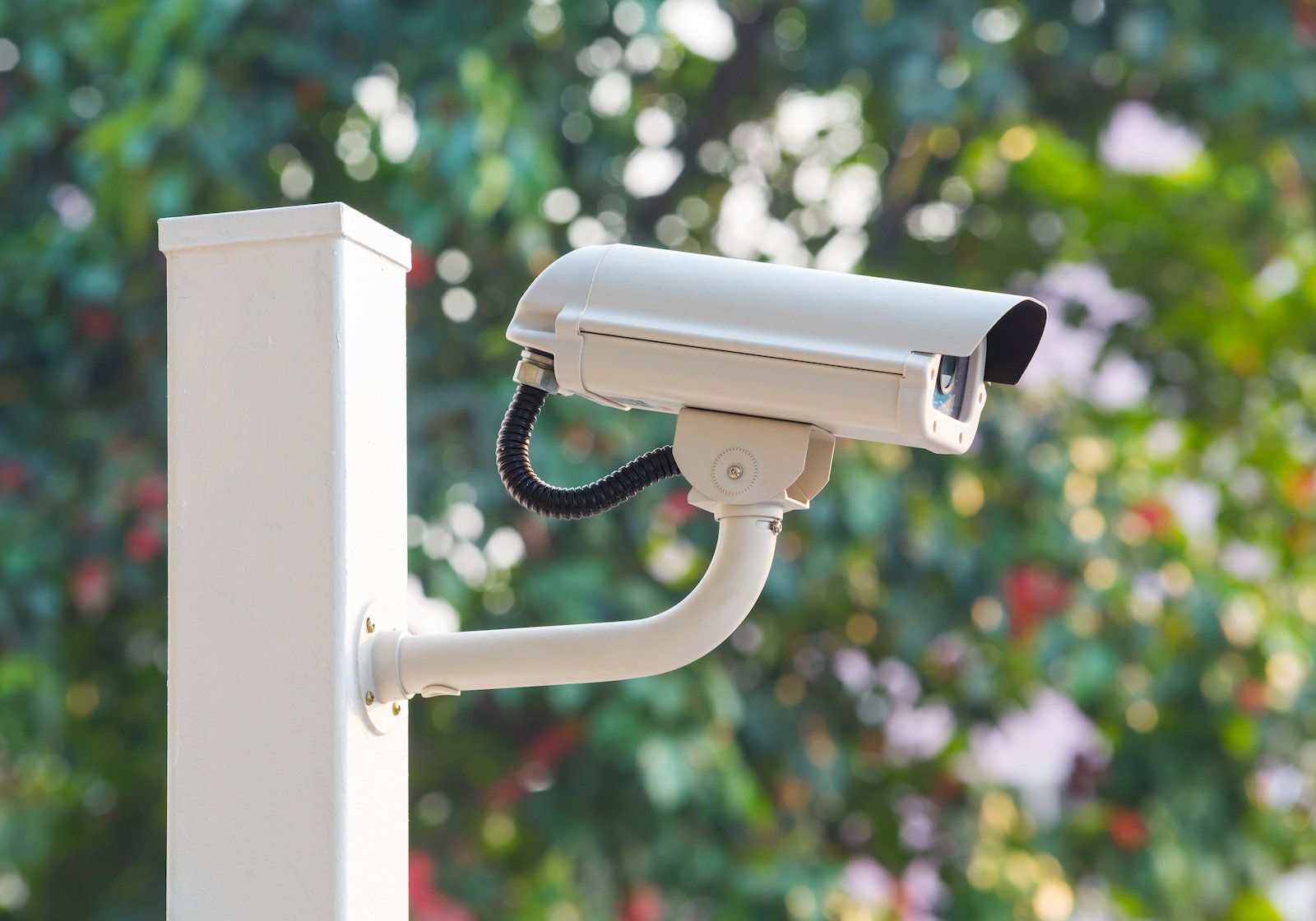 a security camera attached to a white post