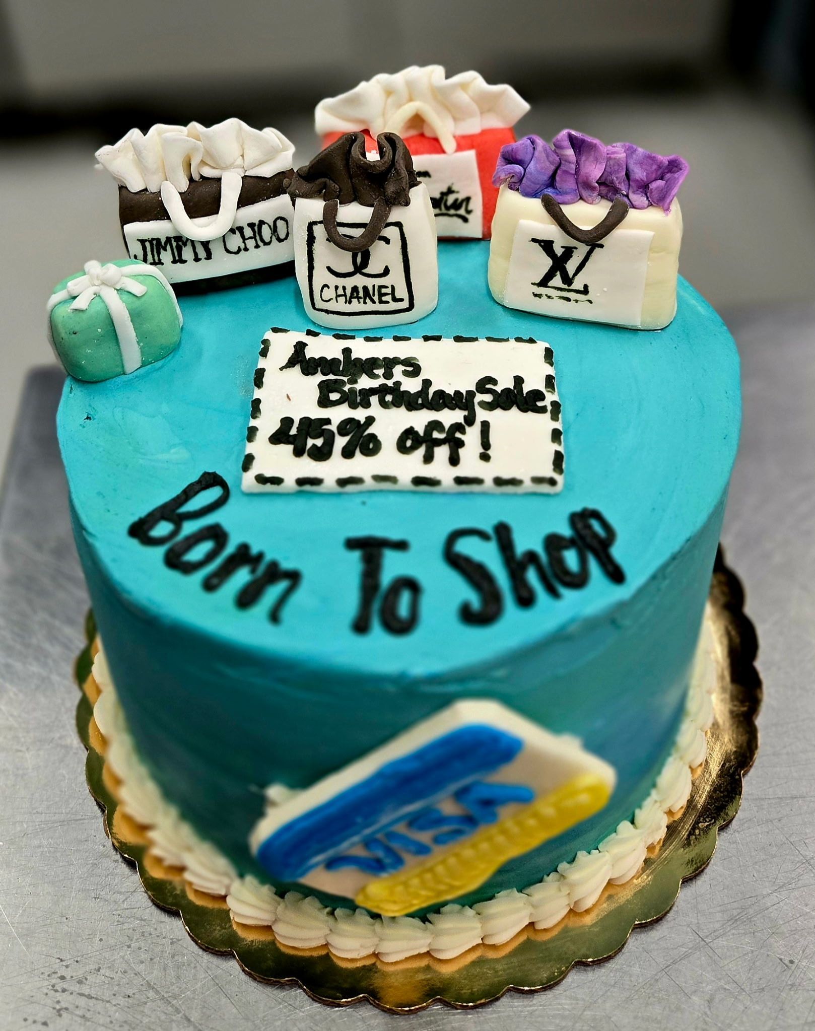 Cake decorated with shopping bags, a credit card, and text: