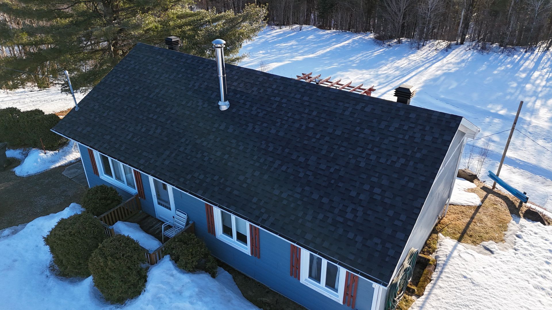 The roof of a house with a black shingle roof