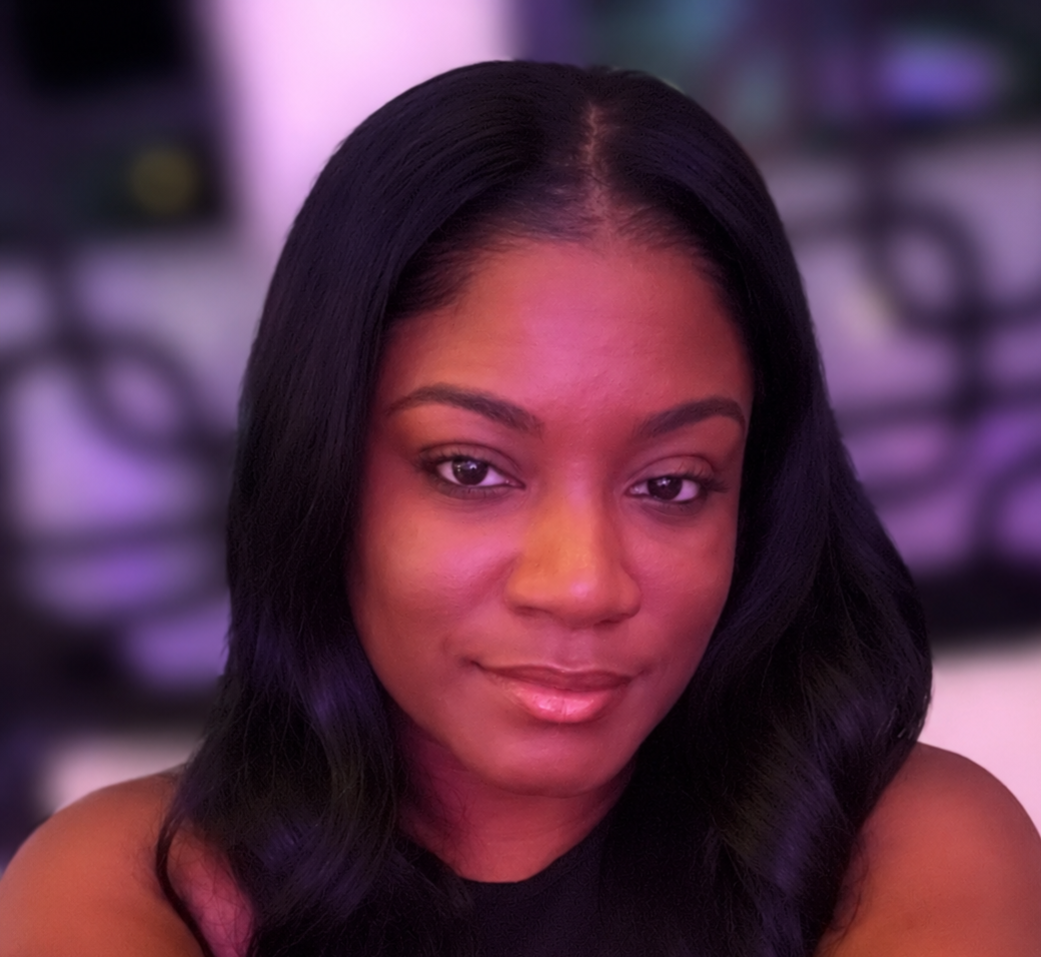 Portrait of a person with long dark hair, softly lit against a blurred purple background