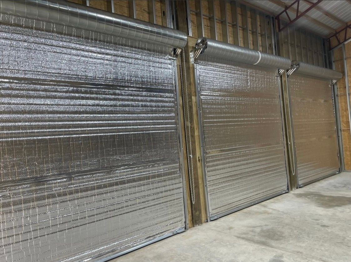 Industrial warehouse wall with large silver insulated panels and a concrete floor