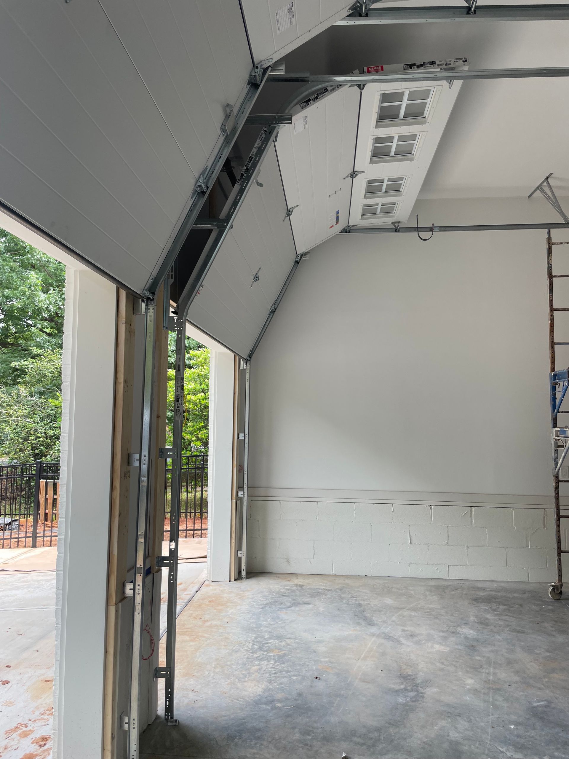 Empty garage interior with open roll-up door and daylight coming in