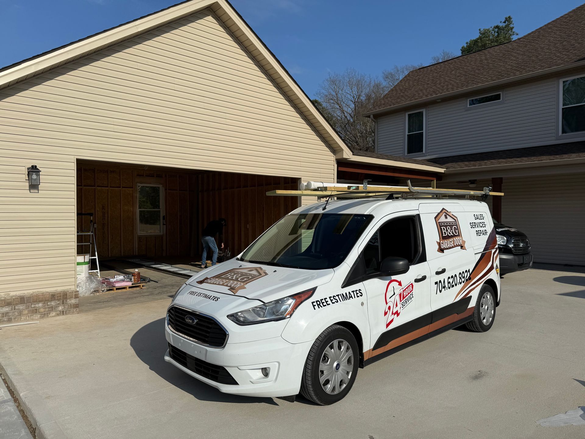 White service van with red graphics parked in front of a beige house and garage.