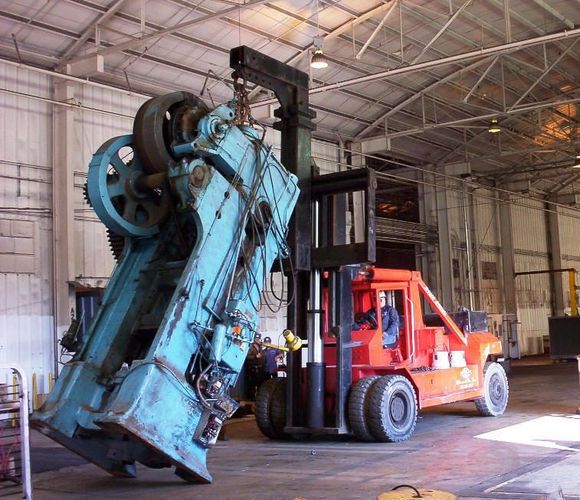 A red crane is lifting a machine into the air. A red crane is lifting a machine into the air.