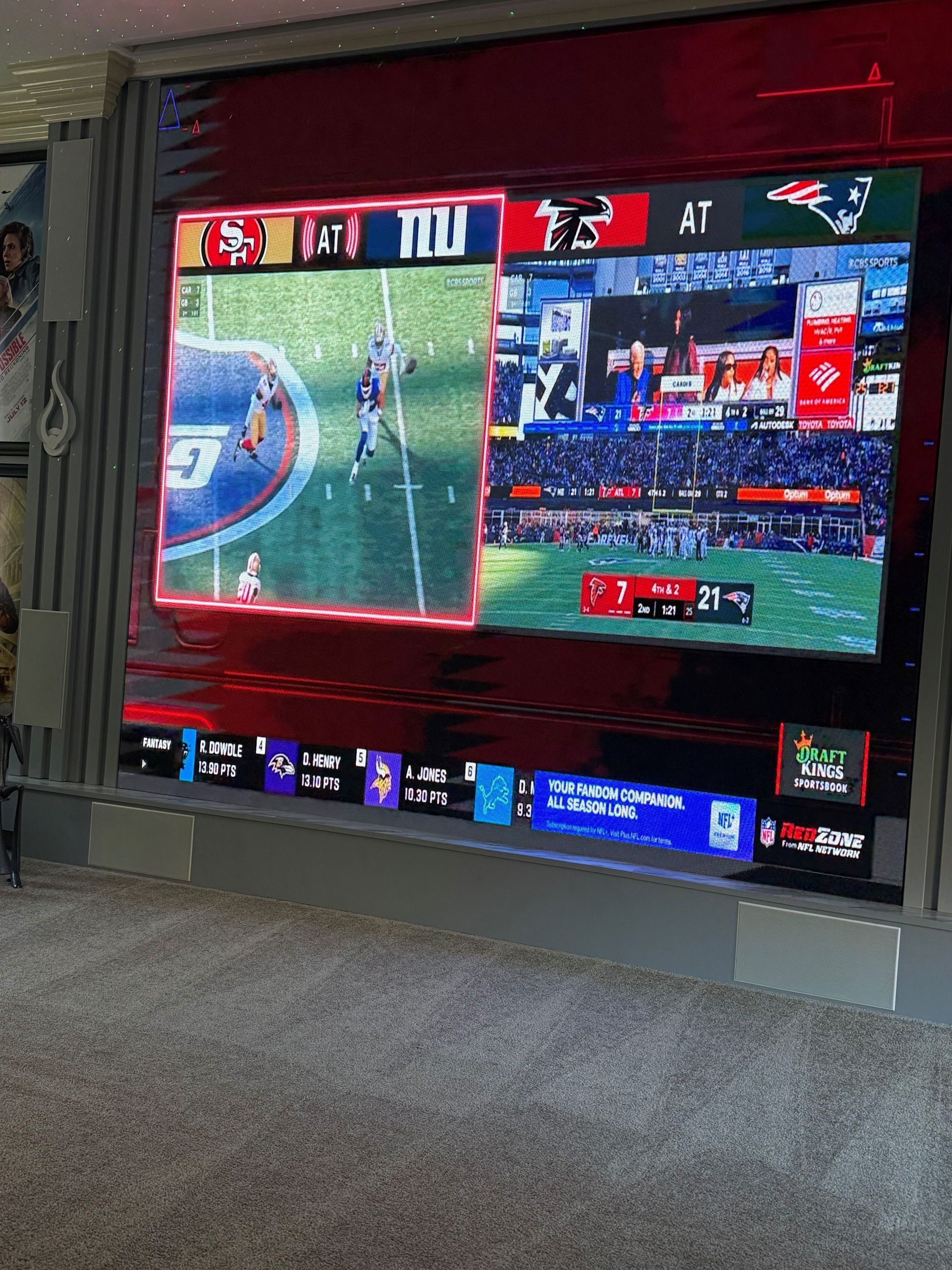 TV showing a football game on a split screen in a living room, with scores and graphics visible