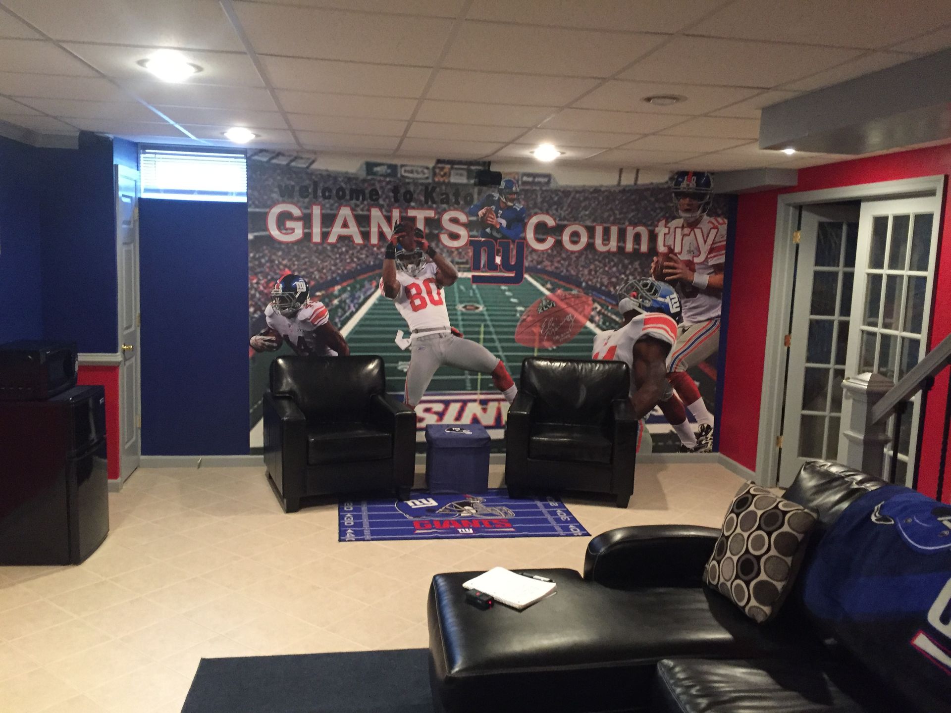 Giants sports-themed lobby with chairs, mural, and large football-themed wall banner