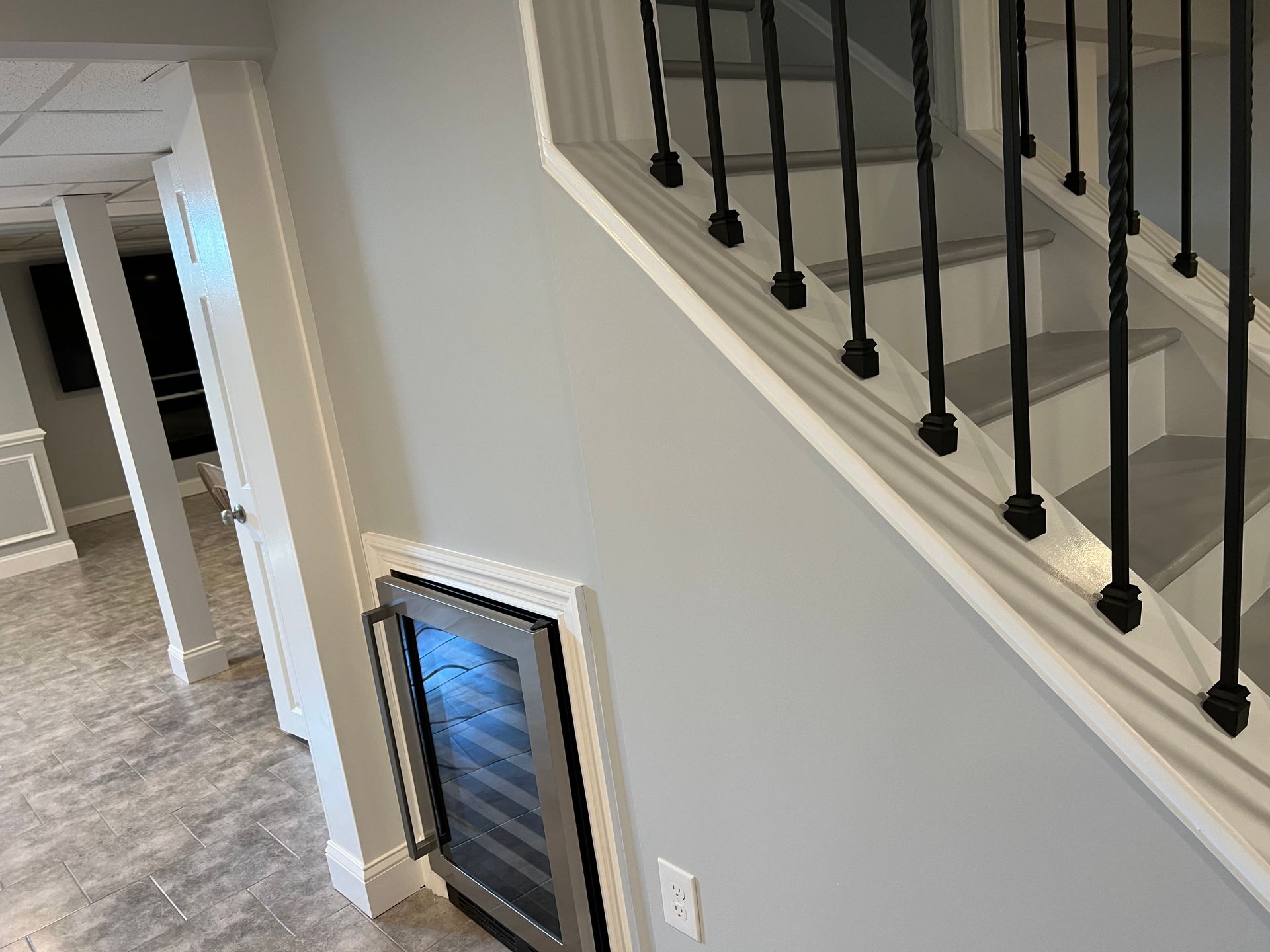 Staircase and hallway in a modern home, with a framed item leaning against the wall