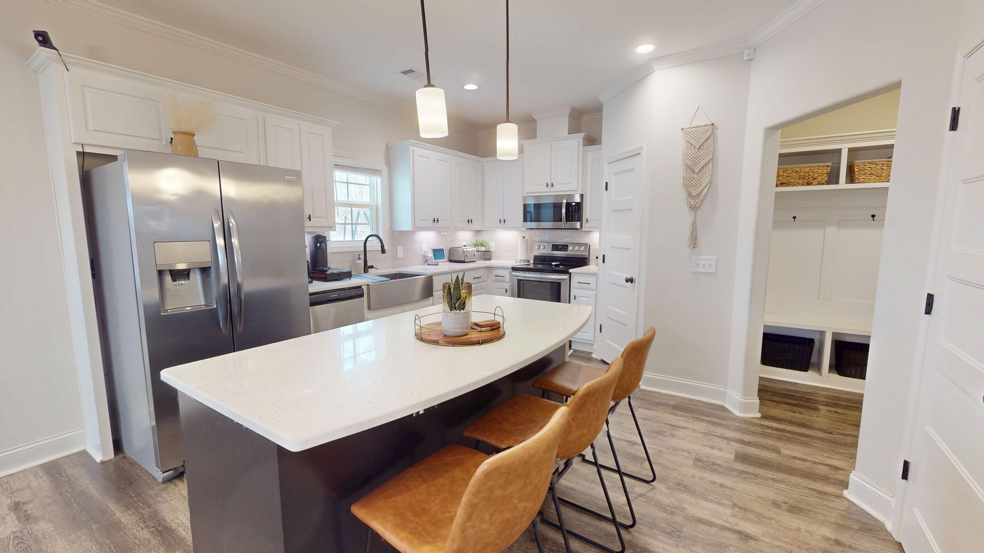 A kitchen with white cabinets and a large island in the middle.