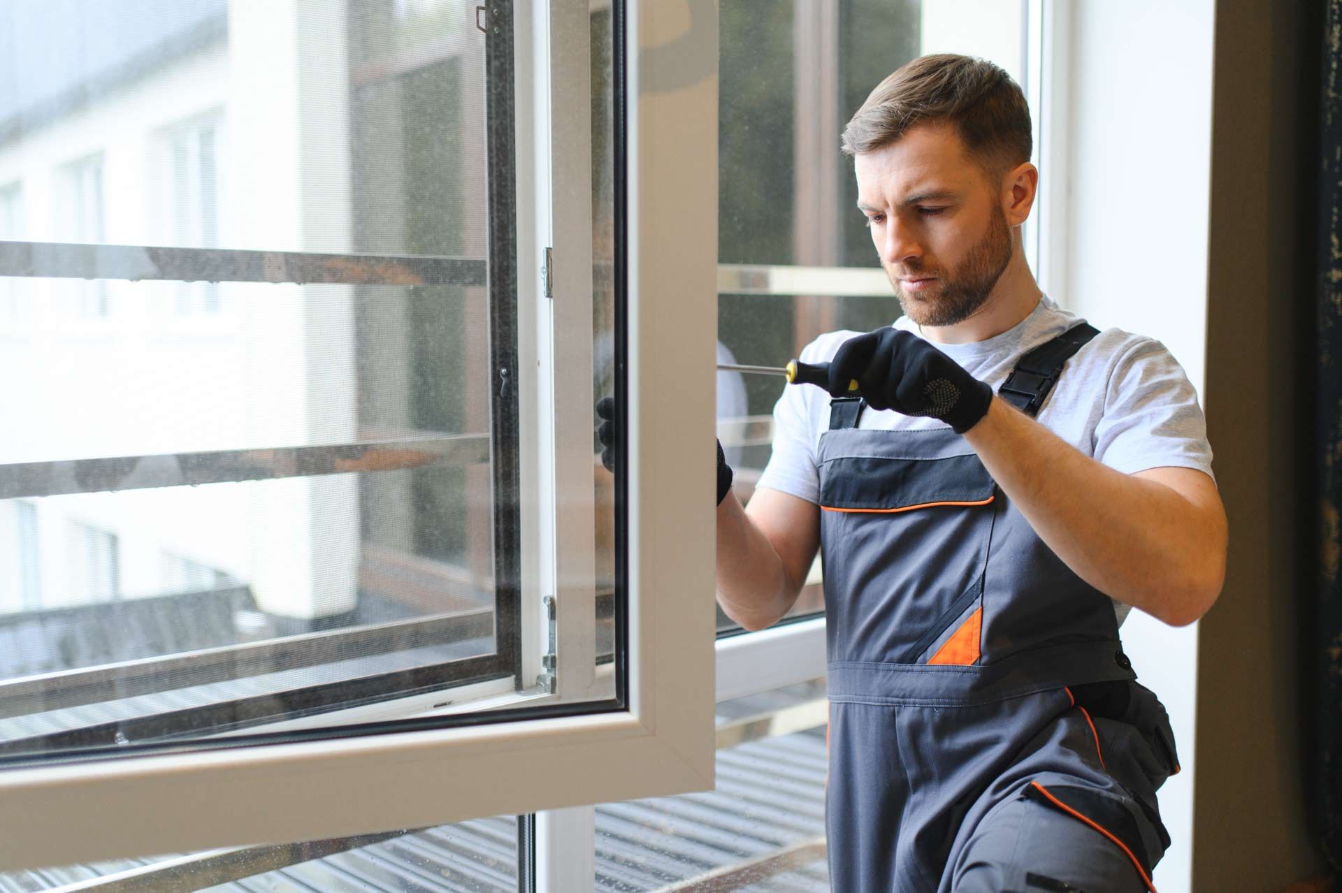 A man is fixing a window with a screwdriver.