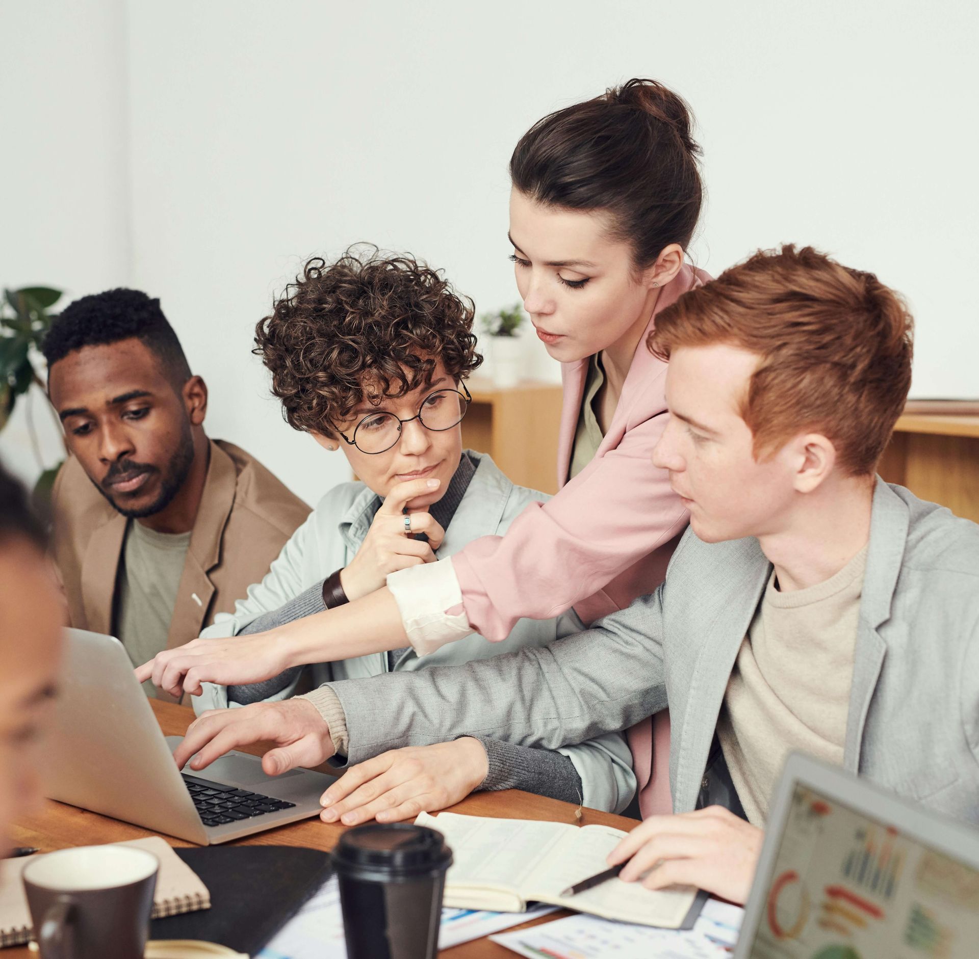A group of early childhood educators looking at a laptop discussing something