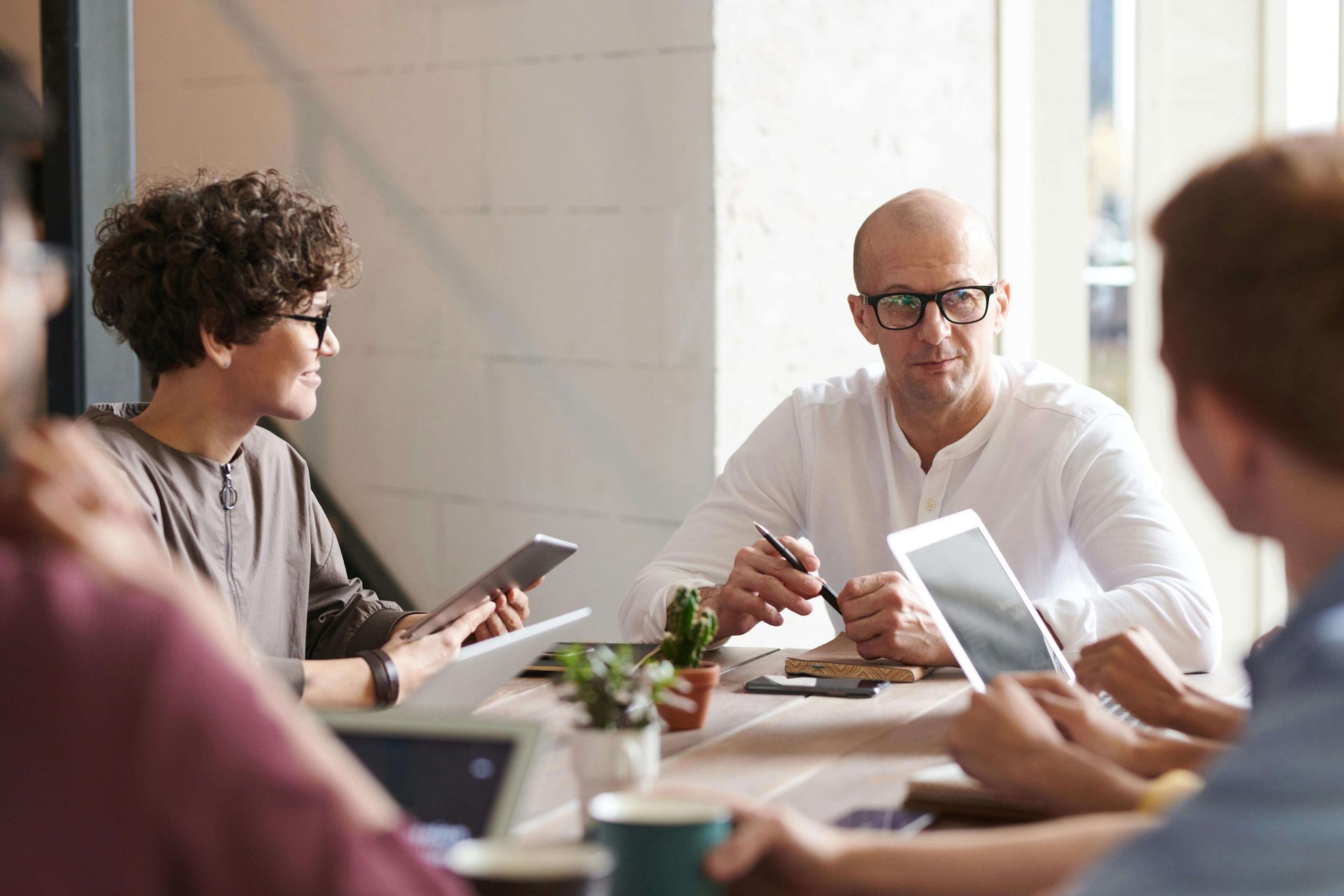 Group of ECE experts at a table during a meeting looking at ipads