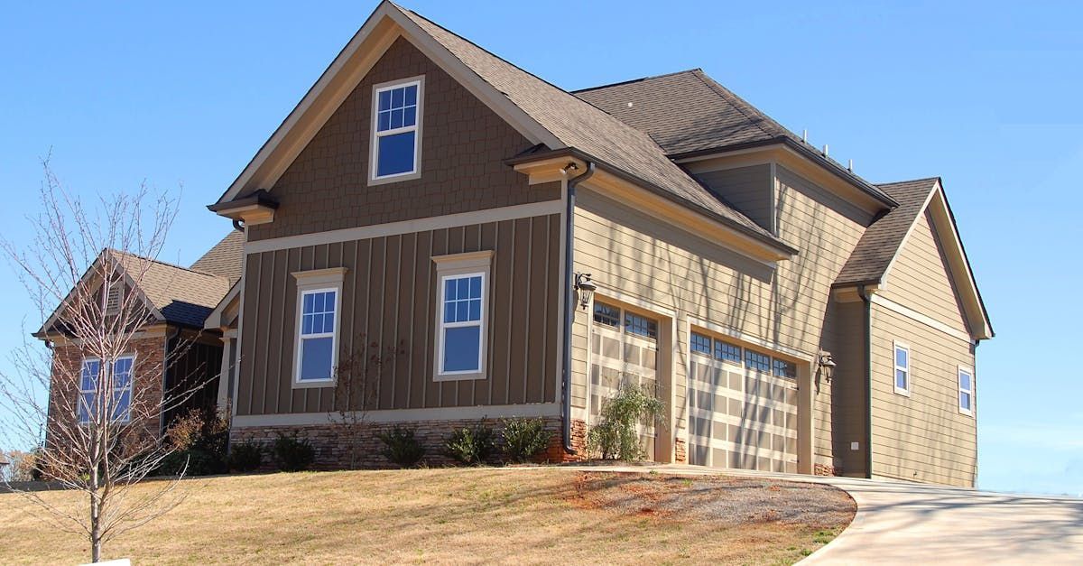 A large brown house with a blue sky in the background