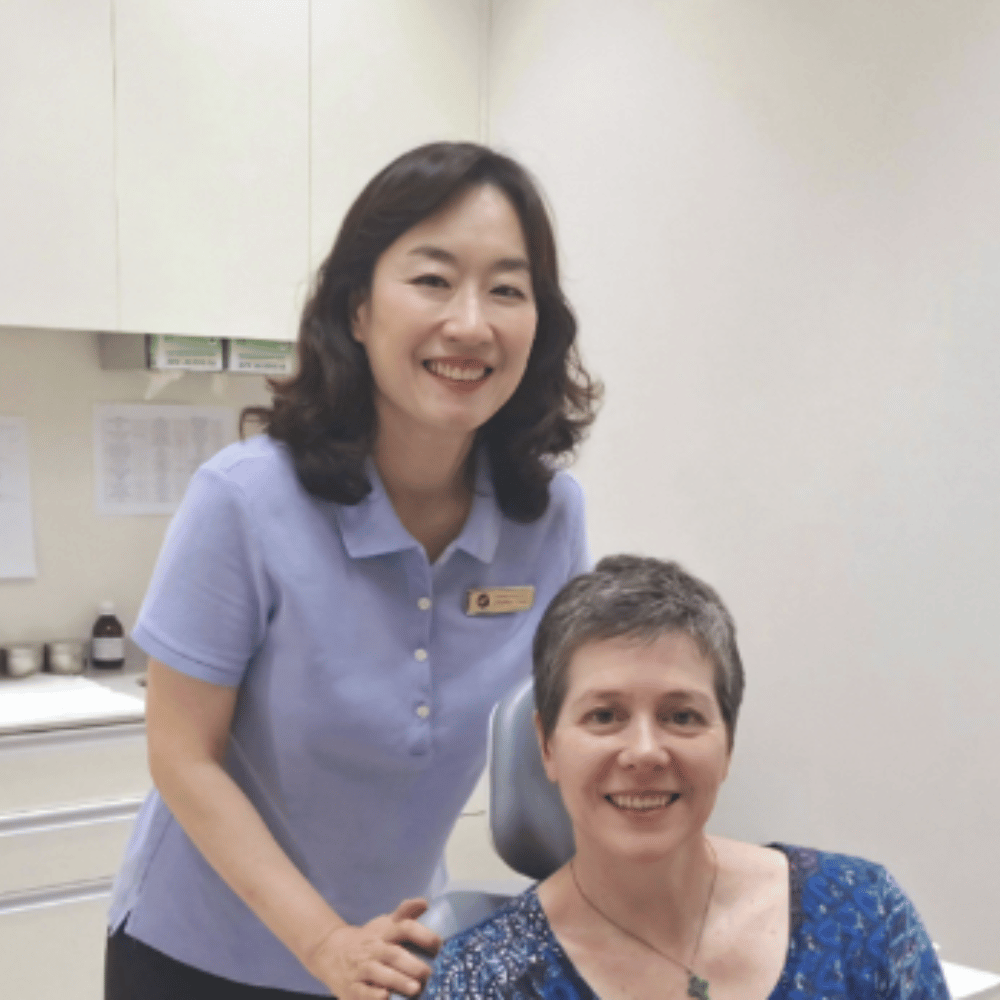 A Plus team member with a smiling international patient