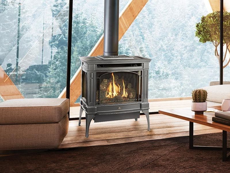 A gas fireplace is sitting in a living room next to a large window.