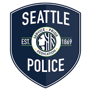 The Seattle Police Department badge: a dark blue shield with white text, a central circular emblem, and