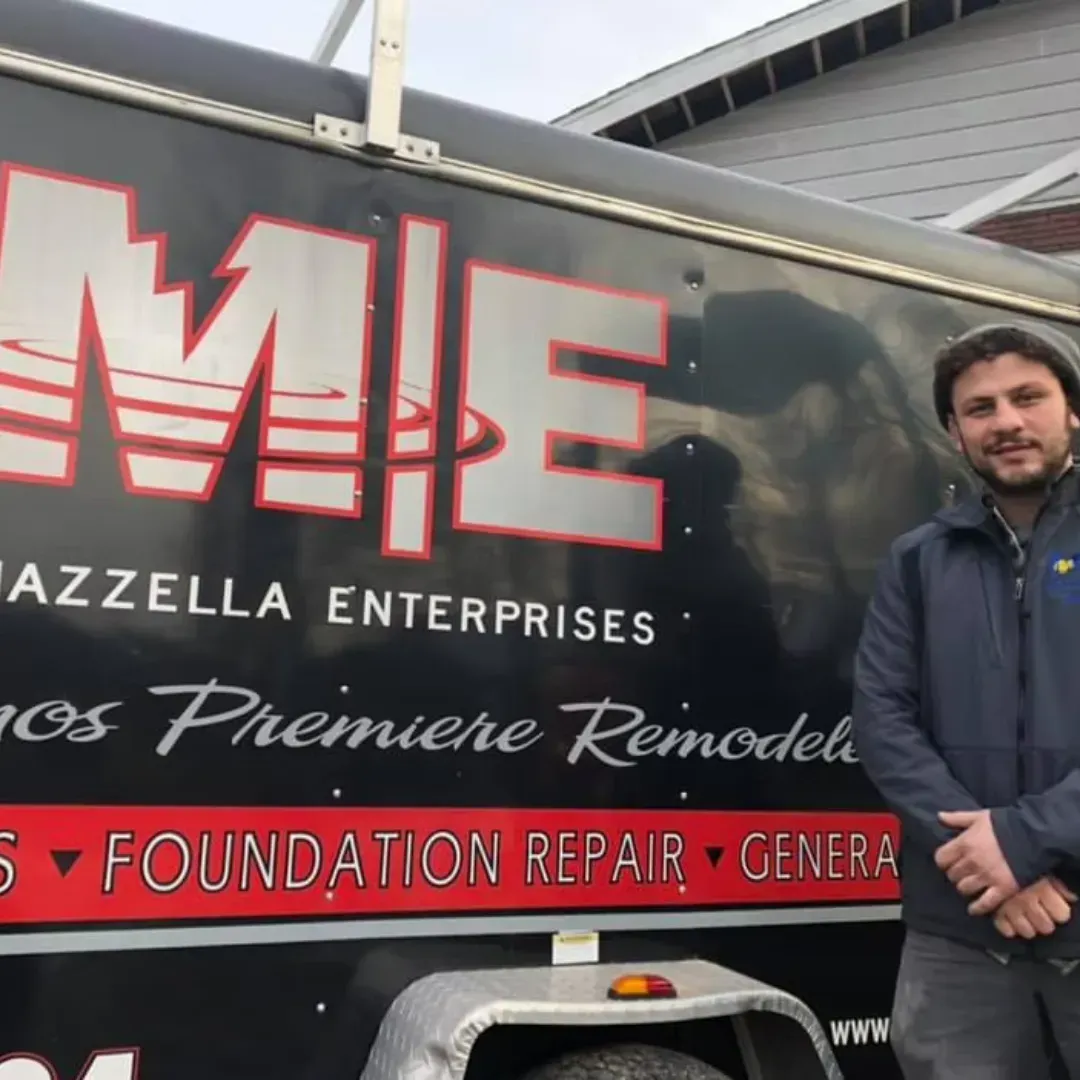 A person stands next to a company trailer labeled Mazzella Enterprises, featuring 