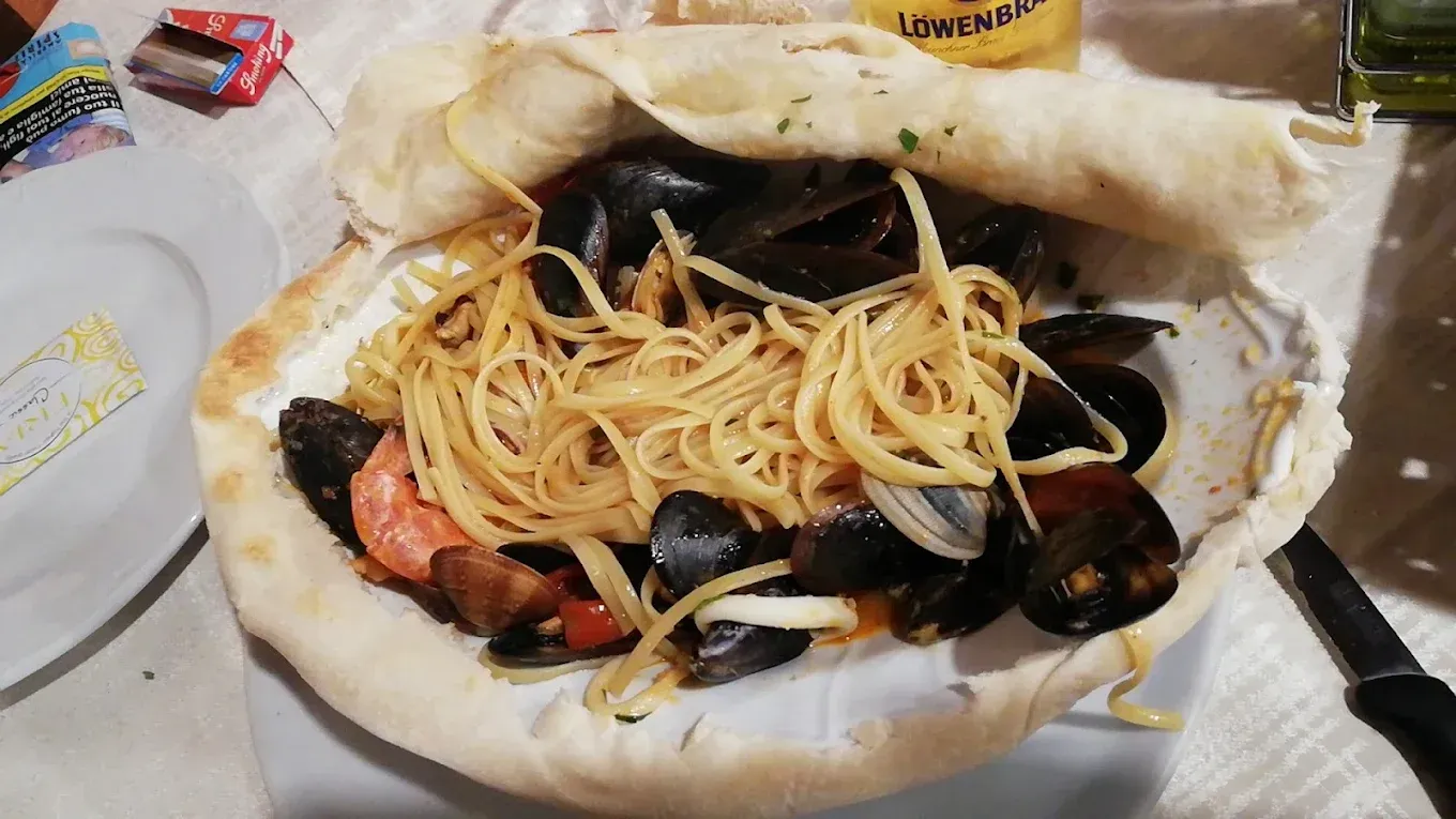 Spaghetti e cozze serviti in una ciotola di crosta; vista ravvicinata.