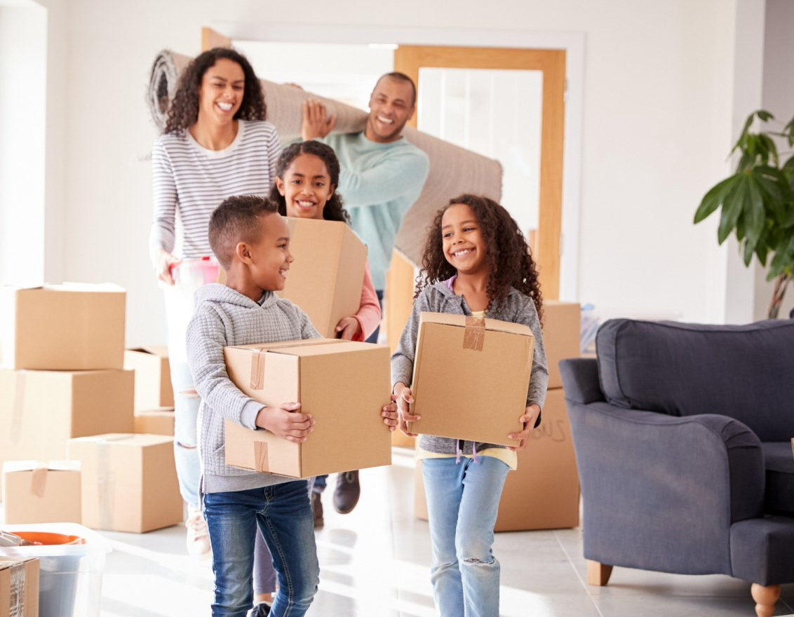 A family is carrying boxes into a new home.