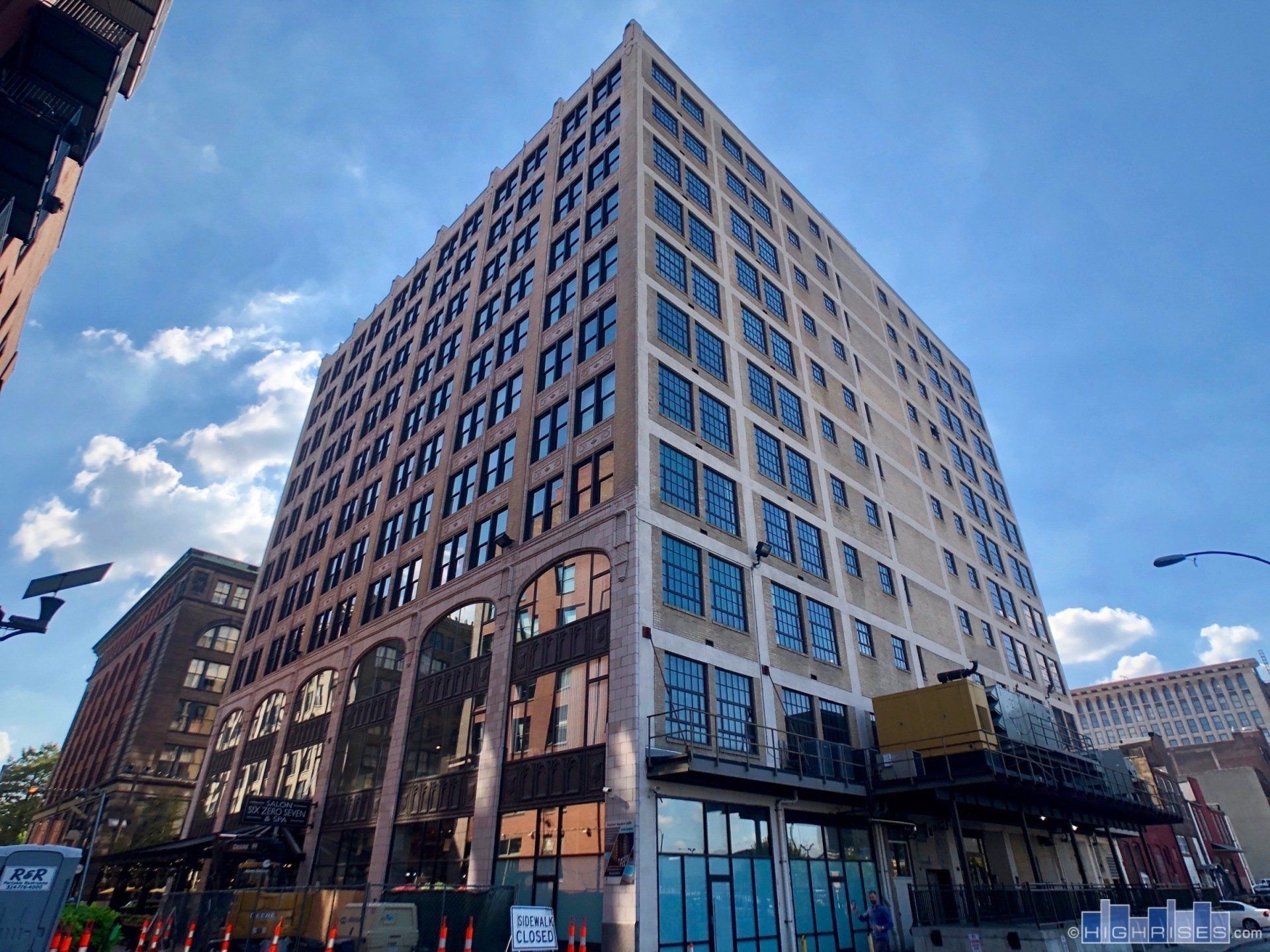 A large building with a lot of windows and a blue sky in the background