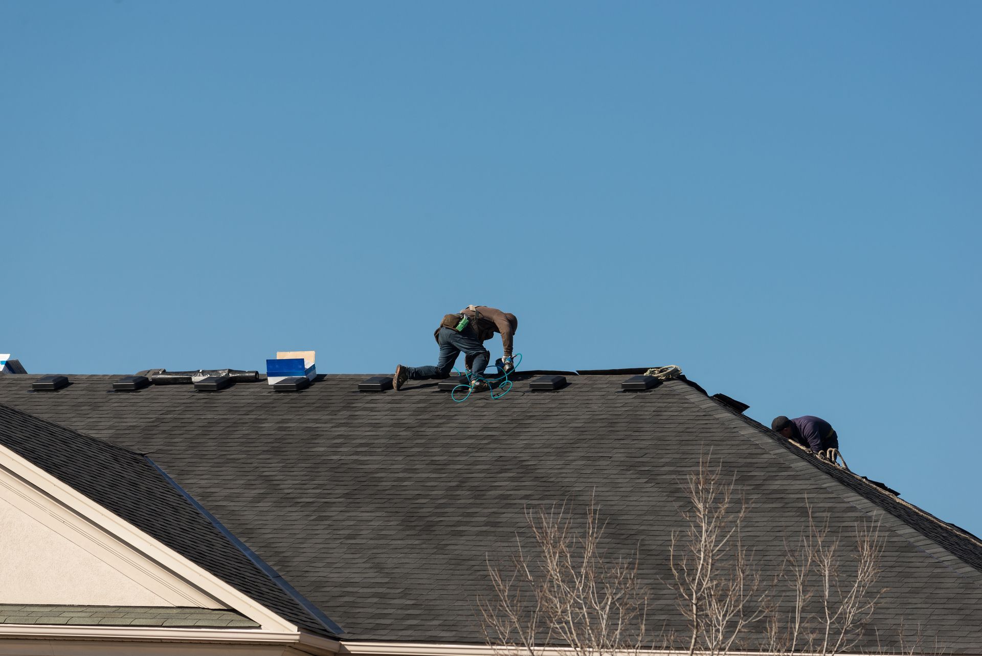 A man redoing a roof on a house