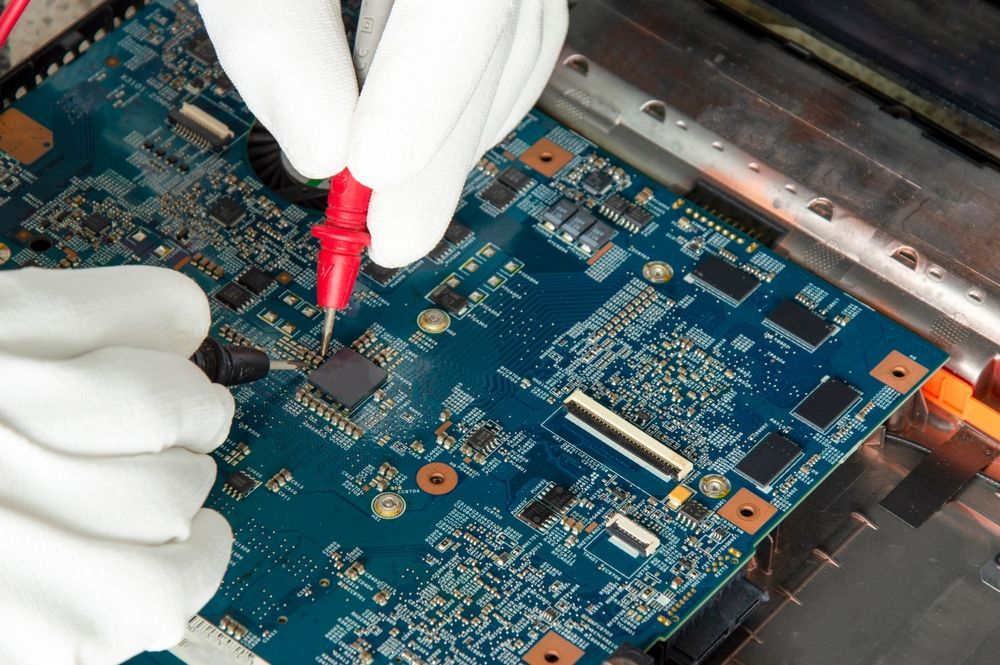 Hands in White Gloves Testing a Blue Circuit Board With Red and Black Probes — Tech Aid In Moffat Beach, QLD