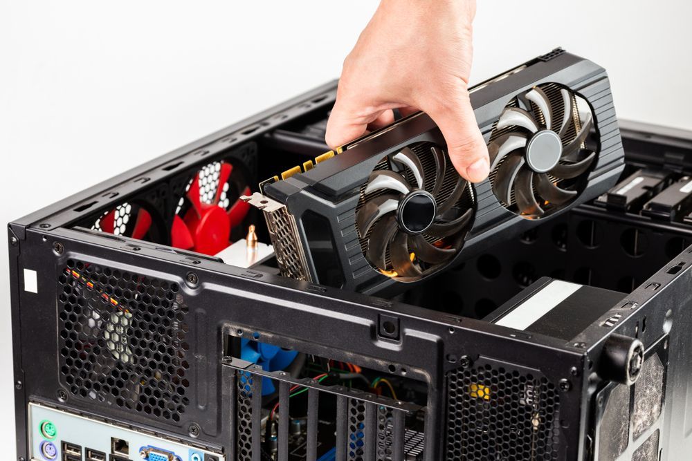 Hand Installing a Black Graphics Card Into a Computer Tower — Tech Aid In Moffat Beach, QLD