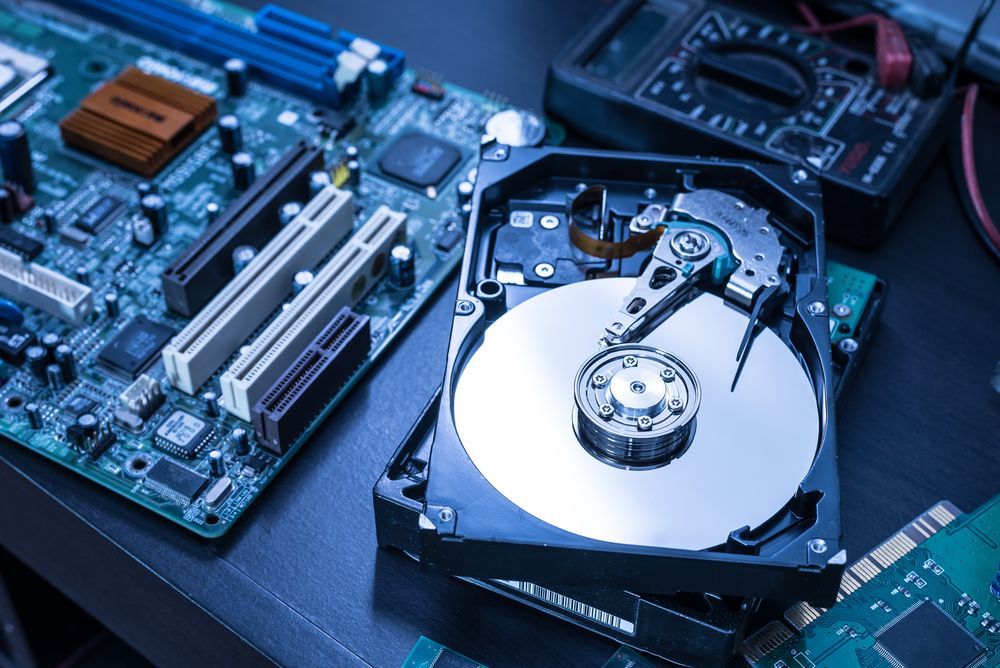 Open Hard Drive Next to Computer Circuit Boards — Tech Aid In Moffat Beach, QLD
