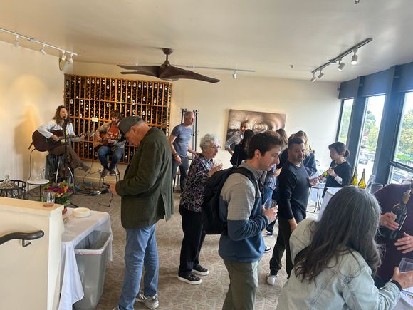 A group of people are sitting at tables with their hands in the air.