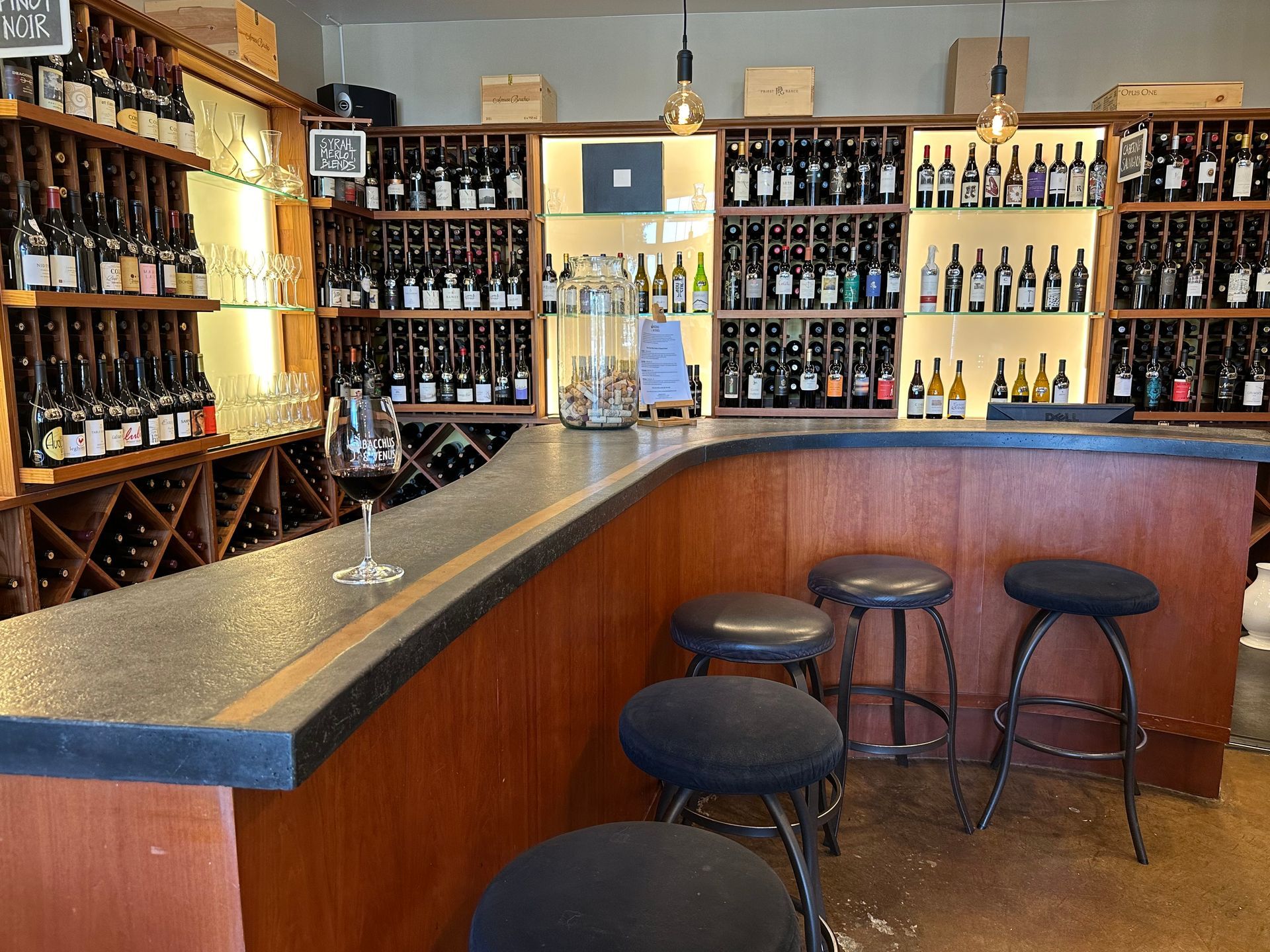 A bar with stools and bottles of wine and a sign that says 34 on it