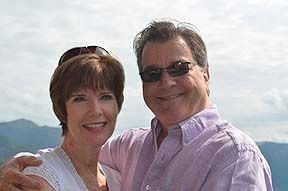 A man and a woman are standing next to each other and smiling for the camera.