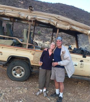 A man and a woman are posing in front of a jeep
