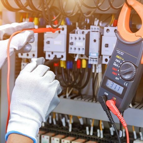 A person is using a clamp meter to test an electrical circuit.