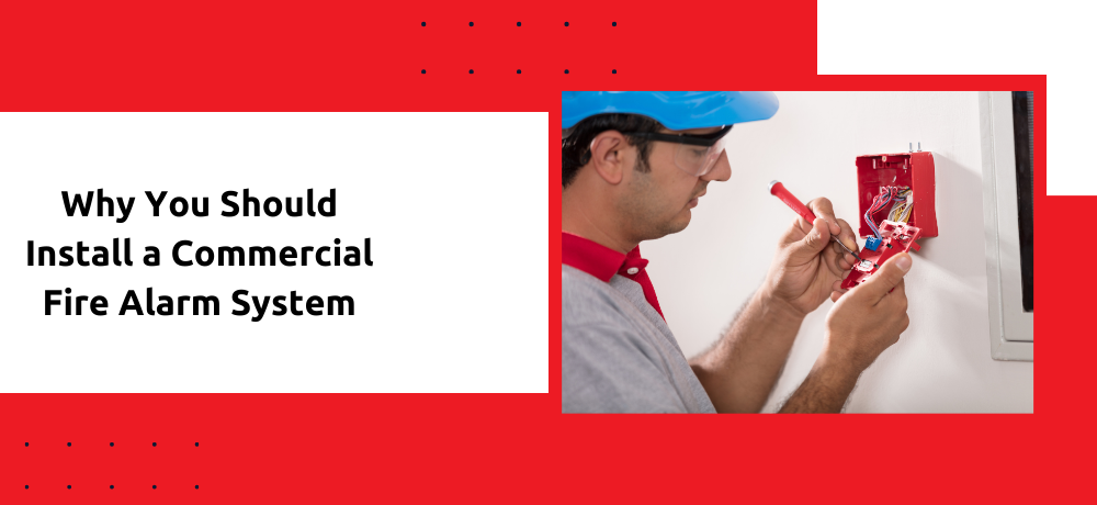 A man is installing a commercial fire alarm system on a wall.