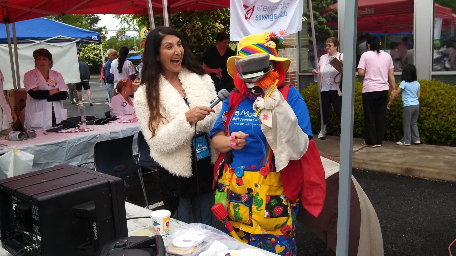 A woman in a clown costume is talking into a microphone