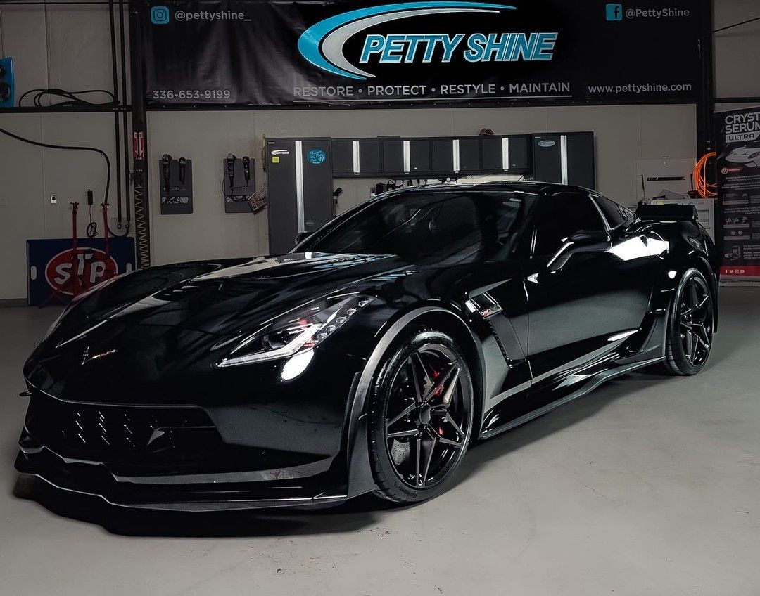 Black Corvette sports car in a garage with 