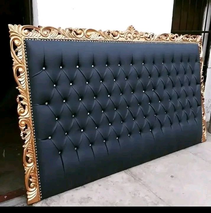 Cabecero de color negro con mechones y marco adornado en dorado.