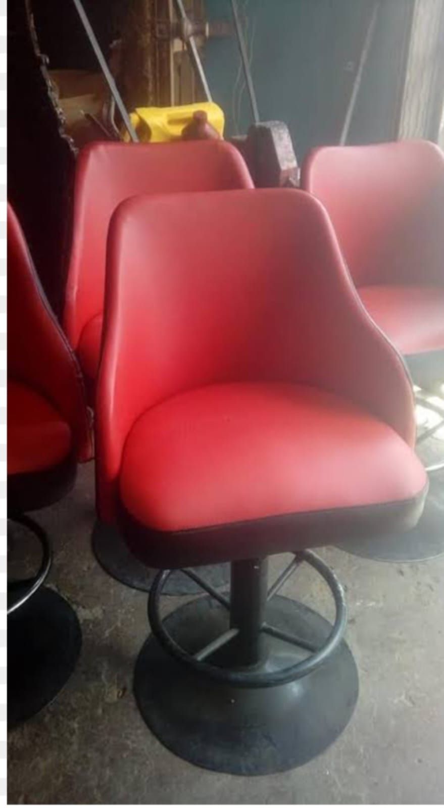 Taburetes de bar giratorios rojos con bases negras.