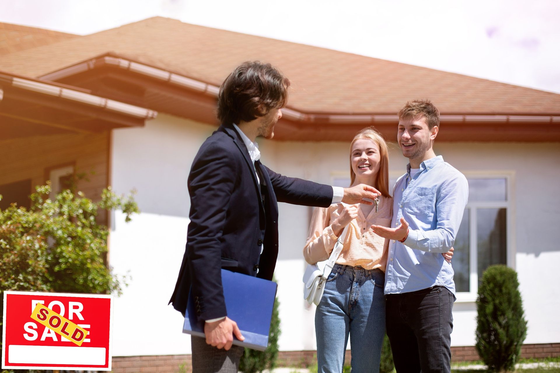 Real estate agent greeting a smiling couple outside a house with a 
