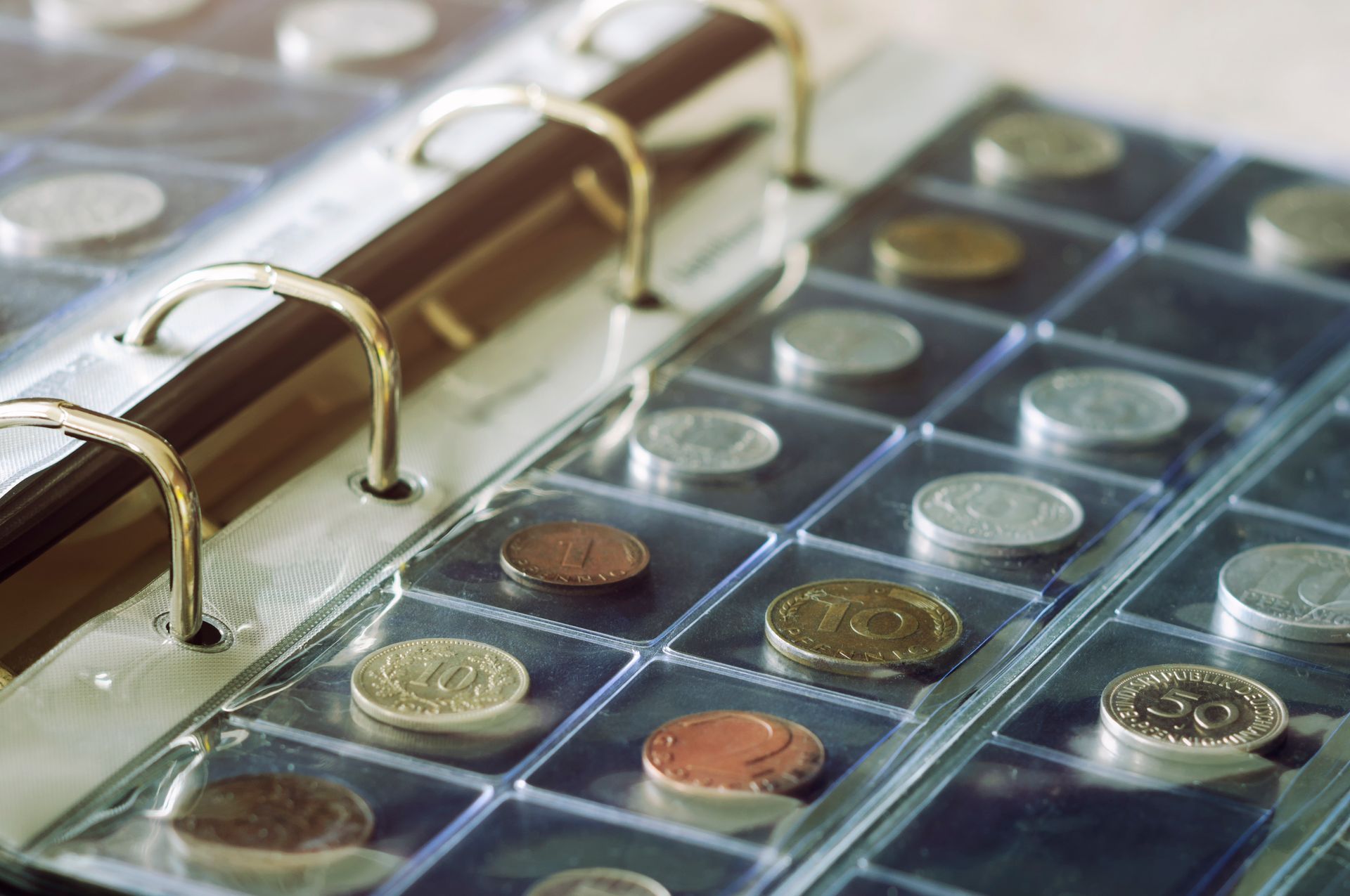 A binder filled with coins including one that has the number 50 on it