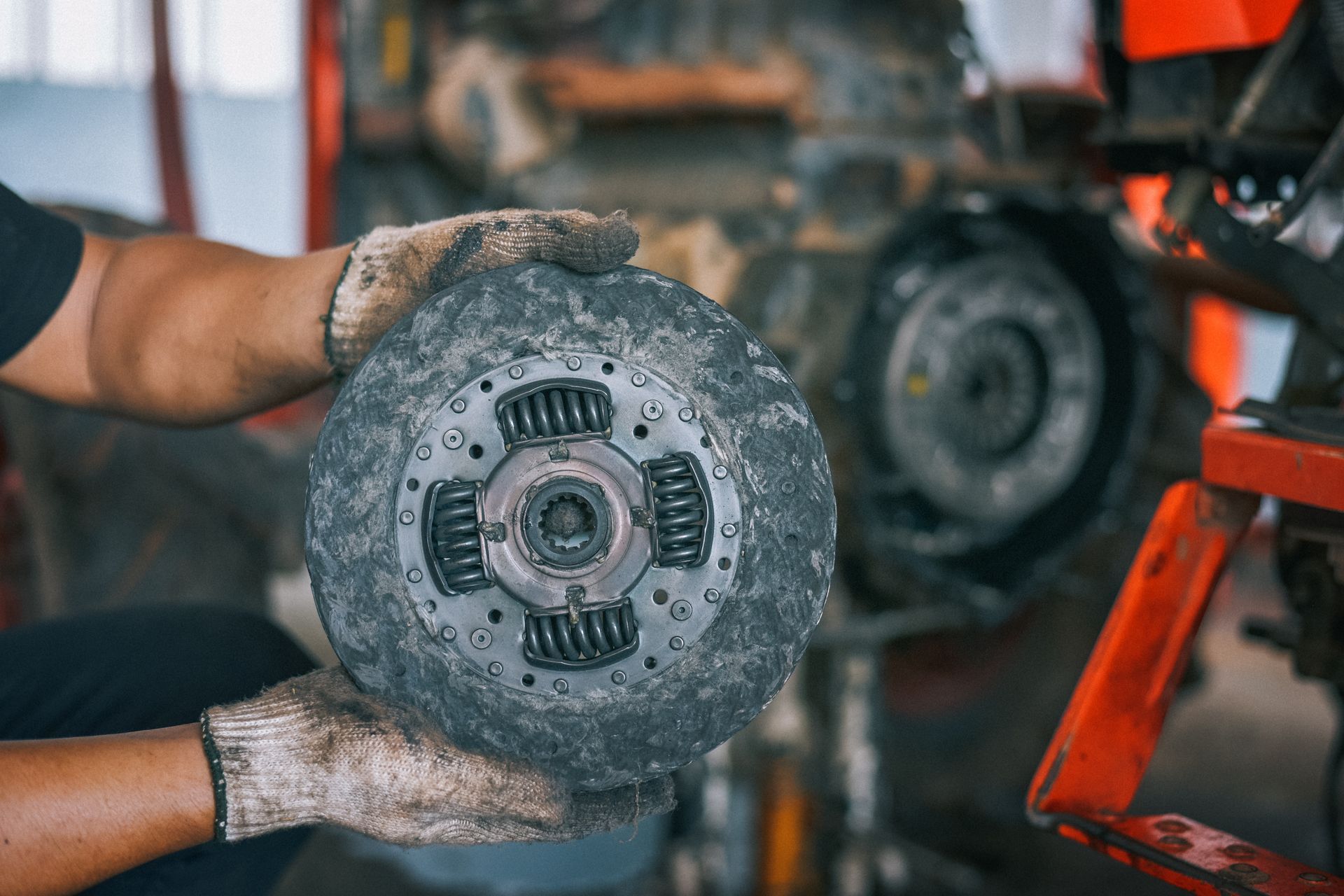 A close-up of a mechanic changing a clutch at a car repair shop