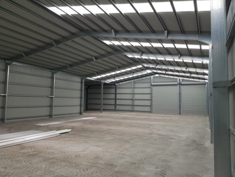An Empty Warehouse With A Roof That Has A Lot Of Lights On It — Shed Constructions (QLD) In Bundaberg, QLD