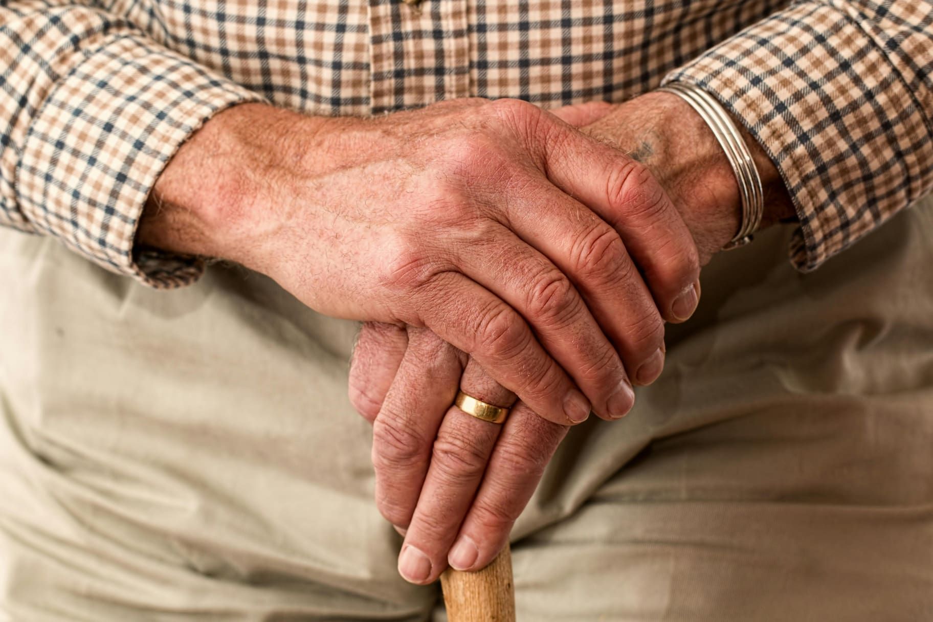 A elderly person hands on top of eachother.