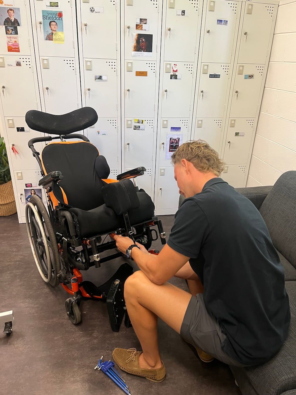 A person adjusting a wheelchair during a wheelchair assesment