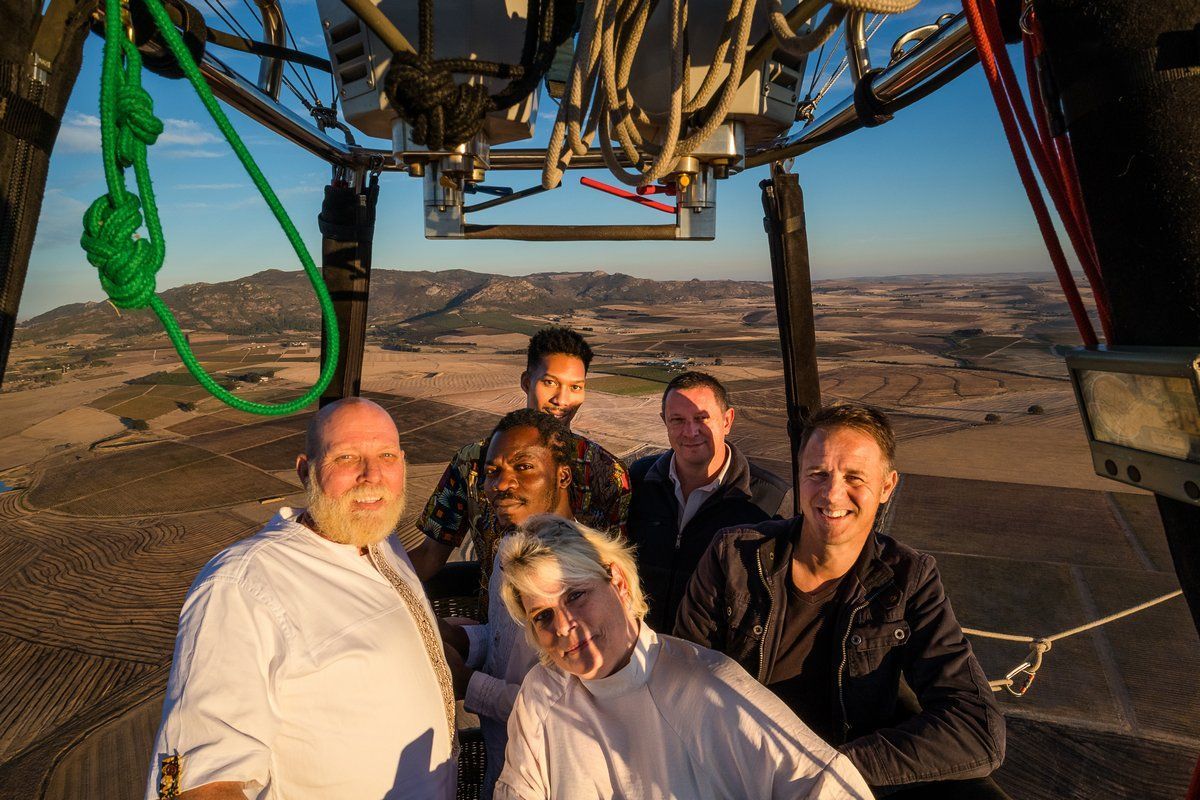 A group of people are sitting in a hot air balloon.