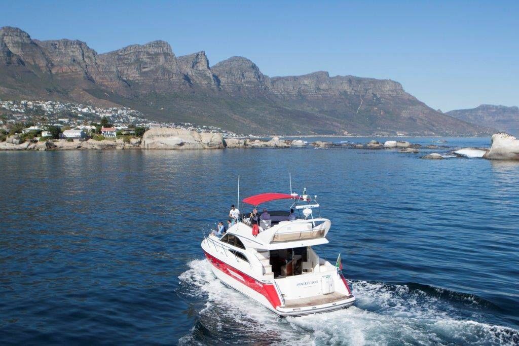 A boat is floating on top of a body of water with mountains in the background.