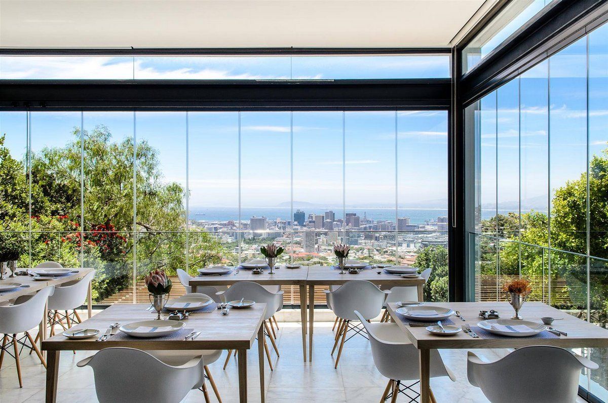 A restaurant with tables and chairs and a view of the city.